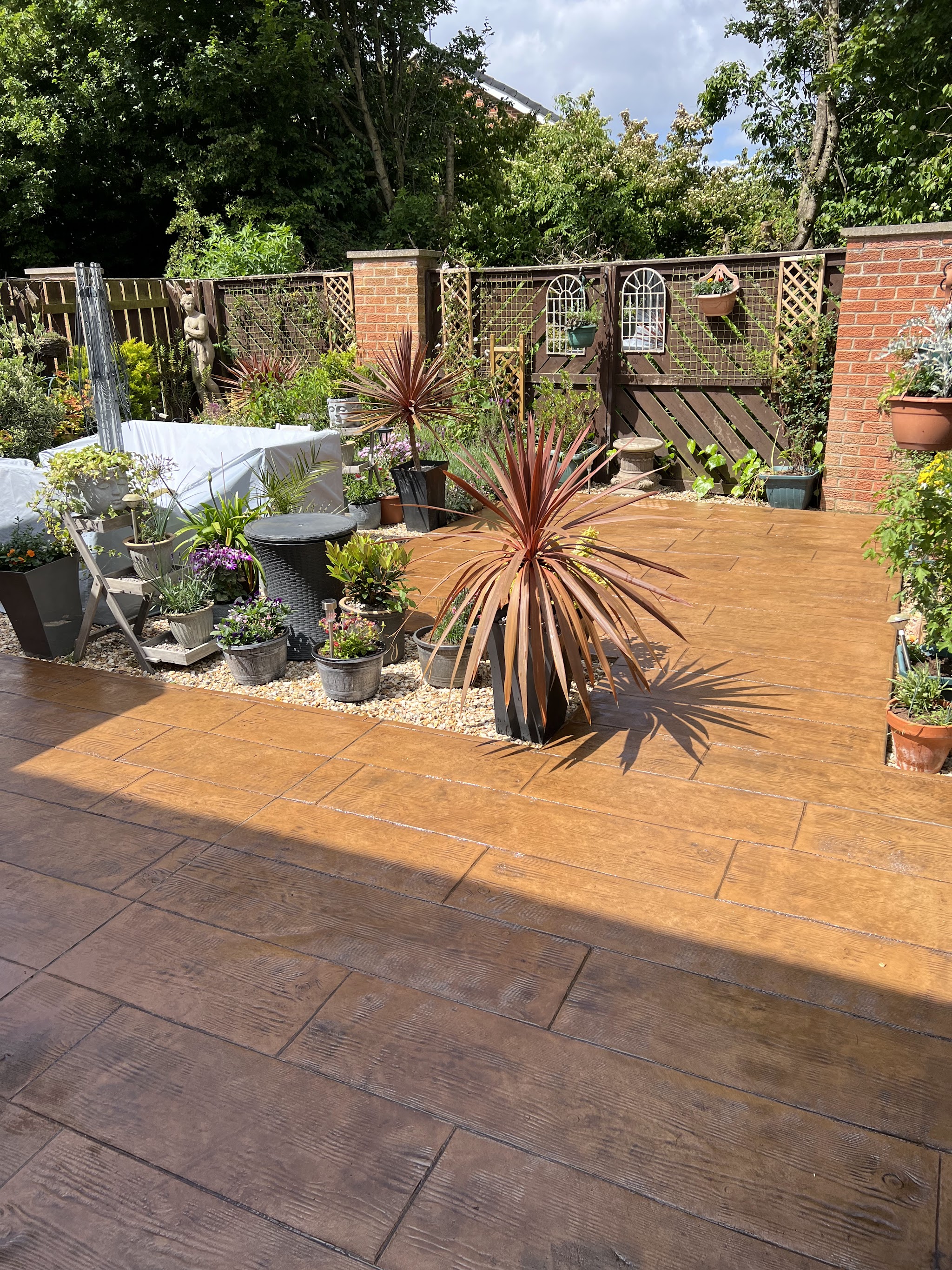 Tan printed patio in a back garden with potted plants